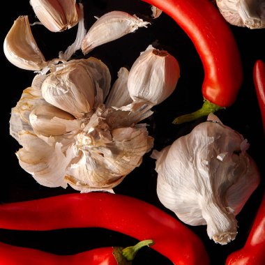 Sarımsak ve kırmızı biber siyah bir arka plan, üstten görünüm.