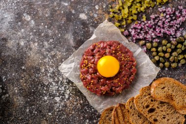 Taze Beef Tartar sarısı ile servis edilir, kızarmış ekmek, turşu cucu