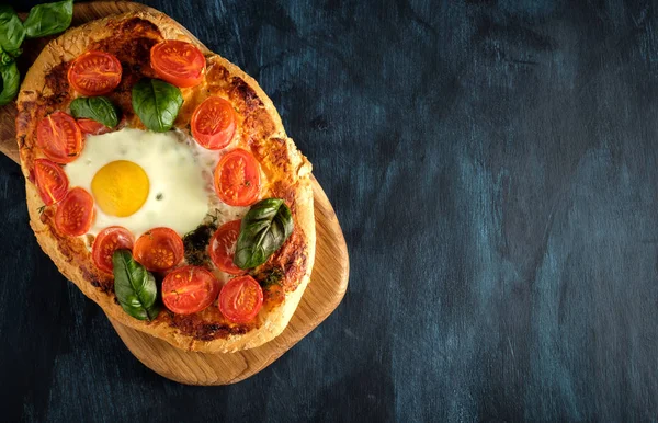 Pizza caseira saborosa com ovo, queijo, tomate e manjericão . — Fotografia de Stock