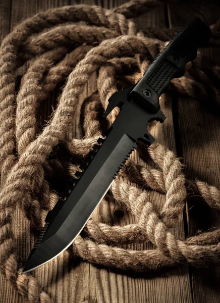 Black combat military knife on wooden table. — Stock Photo, Image