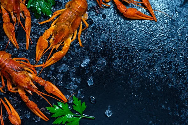 Fresh boiled crawfish with lemons and greens on a dark table wit — Stock Photo, Image