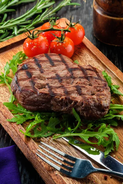 Steak de bœuf grillé sur planche à découper en bois. — Photo