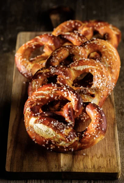 Pretzel suave casero recién horneado con sal en t de madera rústica —  Fotos de Stock