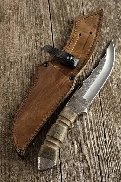 Hunting knife handmade with patterns on the old wooden backgroun — Stock Photo, Image