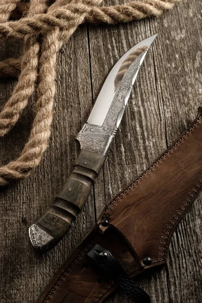 Hunting knife handmade with patterns on the old wooden backgroun — Stock Photo, Image