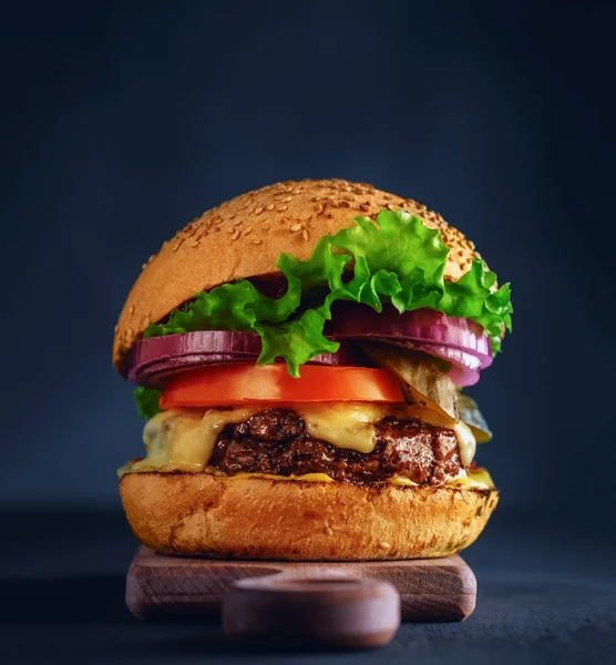 Sabrosa hamburguesa a la parrilla con lechuga, queso y cebolla servida —  Fotos de Stock
