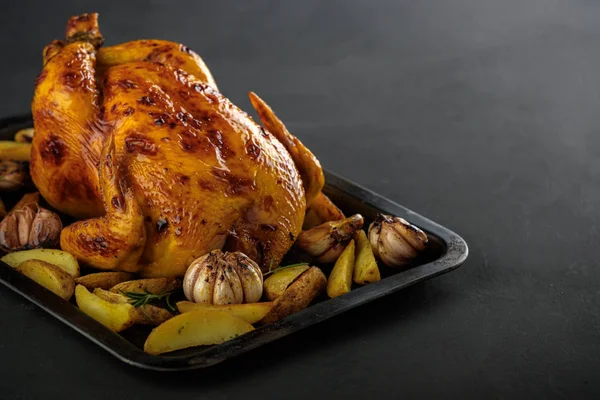 Roasted chicken with potatoes on a baking sheet.
