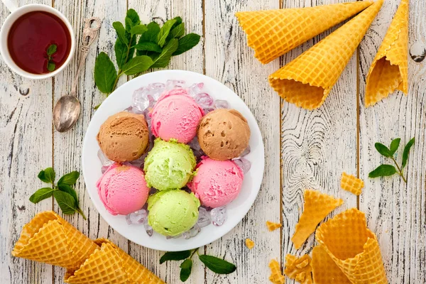 Bolas multicolores de helado de crema en un plato de hielo . — Foto de Stock