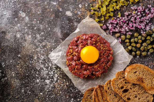 Färsk oxtartar serveras med äggula, stekt bröd, picklad cucu — Stockfoto