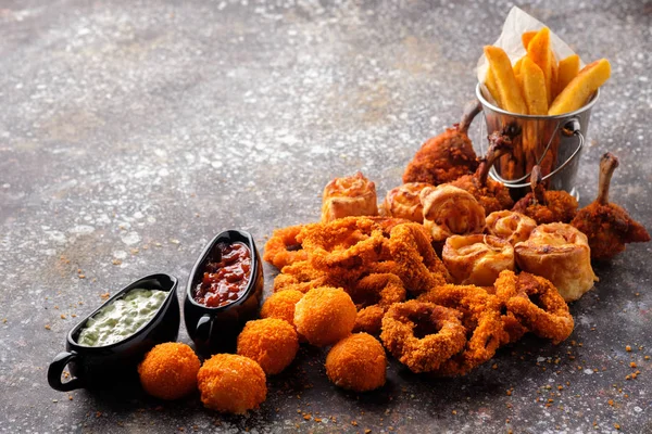 Anneaux oignons, boulettes de pommes de terre et poulet frit aux pommes de terre frites — Photo