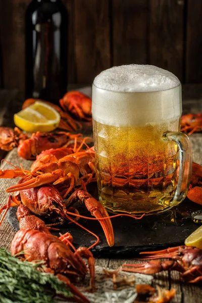 Fresh boiled crawfish and a mug of beer on a wooden table. — Stock Image Fresh boiled crawfish and a mug of beer on a wooden table. Stock Photo