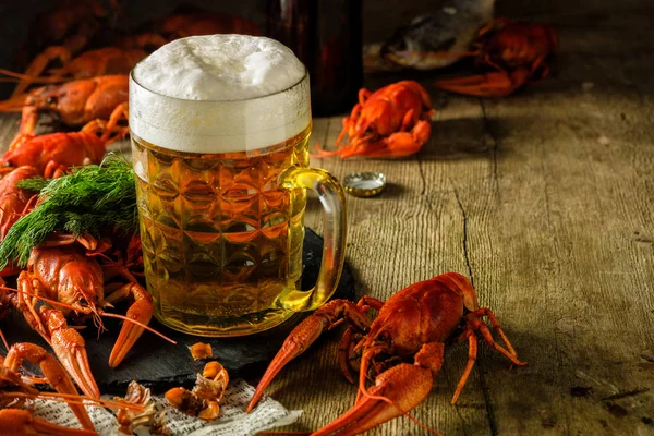 Fresh boiled crawfish and a mug of beer on a wooden table. — Stock Image Fresh boiled crawfish and a mug of beer on a wooden table. Stock Photo