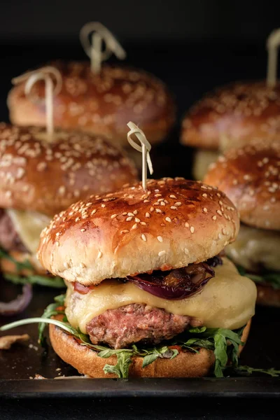 Hambúrgueres suculentos caseiros com carne bovina, queijo e cebola caramelizada . — Fotografia de Stock