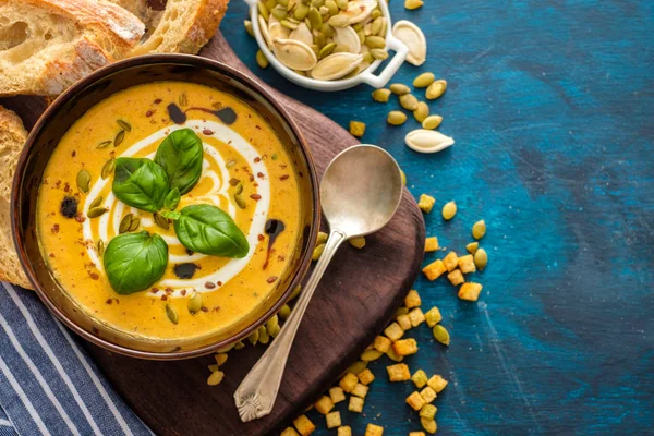 Délicieuse soupe de citrouille maison avec des feuilles de basilic. Vue du dessus . — Photo