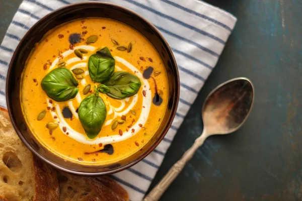 Délicieuse soupe de citrouille maison avec des feuilles de basilic. Vue du dessus . — Photo