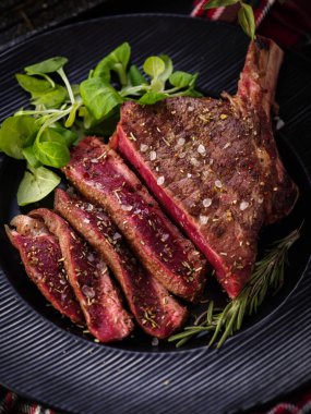 Kemiğe biftek. Kaburga. Siyah tabakta biberiyeli Tomahawk bifteği. Kızarmış, az pişmiş. Entrecote.
