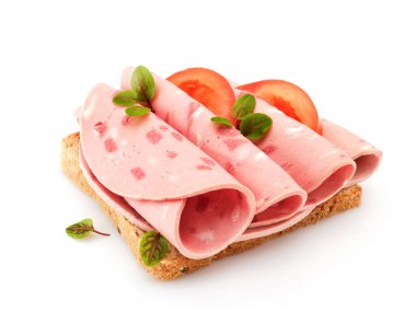 Dilimlenmiş sosisli sandviç, beyaz ekmek, domates ve bitkilerle.