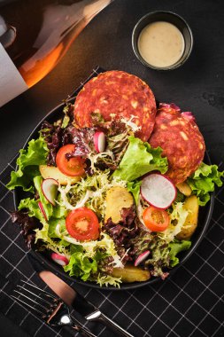 Fırında patates, turp, cervelat ve kiraz domatesli yeşil salata.