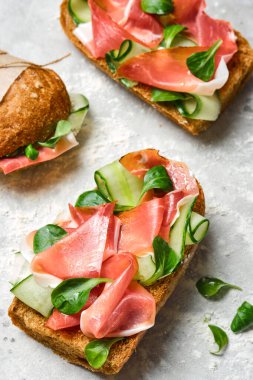 Pastırmalı İtalyan sandviçi, salatalık ve taze otlar. Ciabatta ve et. Üst görünüm.