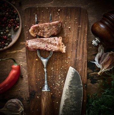 Et çatalının üzerinde orta pişmiş ızgara biftek dilimleri. Çatallı, sulu et parçası..