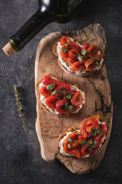 Yumuşak peynirli sandviç ve ahşap tahtada fırında kırmızı dolma biber. İtalyan bruschetta antipasti.