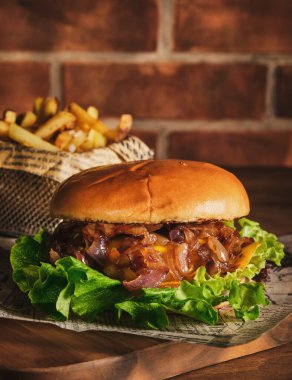 Tahta bir tahtanın üzerinde biftek ve karamelli soğan. Soğan ve sığır etli çizburger. Lezzetli Ev Yapımı Burger