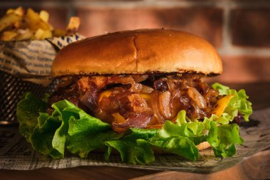 Tahta bir tahtanın üzerinde biftek ve karamelli soğan. Soğan ve sığır etli çizburger. Lezzetli Ev Yapımı Burger