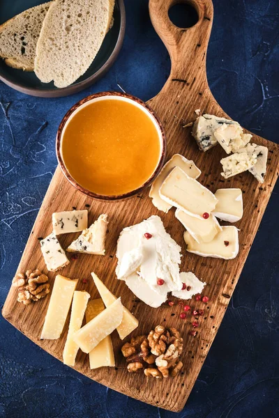 蜂蜜とナッツ入りチーズセット 板の上にチーズの盛り合わせ チーズ前菜セット — ストック写真