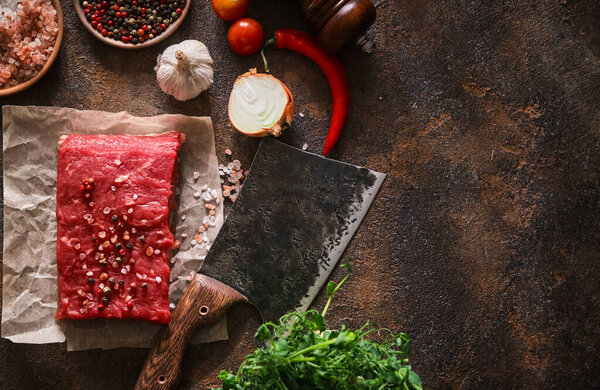 Fresh raw piece of beef with a meat cleaver for a butcher. Top view.
