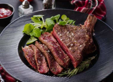 Kemiğe biftek. Kaburga. Siyah tabakta biberiyeli Tomahawk bifteği. Kızarmış, az pişmiş. Entrecote.