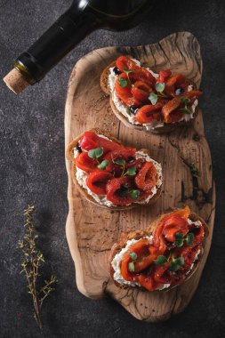 Yumuşak peynirli sandviç ve ahşap tahtada fırında kırmızı dolma biber. İtalyan bruschetta antipasti.