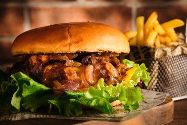 Tahta bir tahtanın üzerinde biftek ve karamelli soğan. Soğan ve sığır etli çizburger. Lezzetli Ev Yapımı Burger