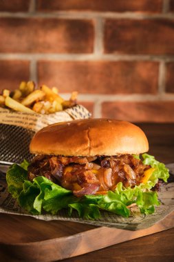 Tahta bir tahtanın üzerinde biftek ve karamelli soğan. Soğan ve sığır etli çizburger. Lezzetli Ev Yapımı Burger