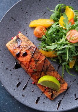 Roka salatası, vişneli domates ve portakallı sıcak füme somon. Sağlıklı beslenme. Üst görünüm.