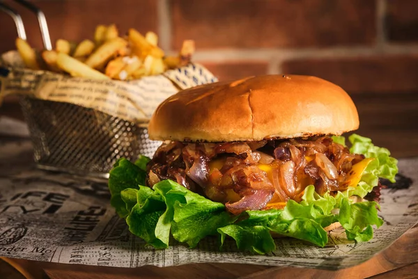 Burger with beef and caramelized onions on a wooden board. Cheeseburger with onion and beef. Juicy Delicious Homemade Burger