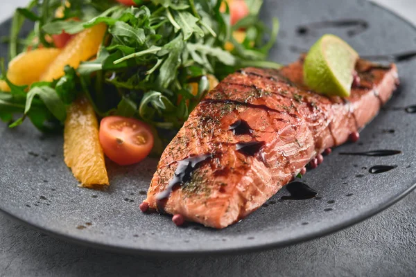 Hot smoked salmon with arugula salad, cherry tomato and orange. Healthy eating