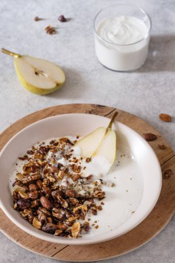 Armutlu ve Yunan yoğurtlu granola. Vejetaryen kahvaltısı. Sağlıklı beslenme
