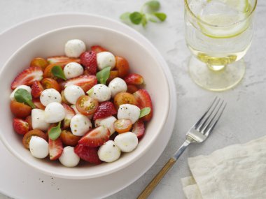 Mozzarella soslu salata, çilek ve vişneli domates. Sağlıklı beslenme vejetaryen salatası.