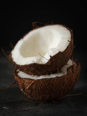 Koyu arkaplanda hindistan cevizi yarıları, yakın plan..