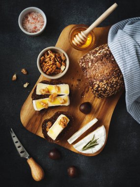 Kahvaltı konsepti. Taze ekmek, peynirli peynir, bal ve ceviz.