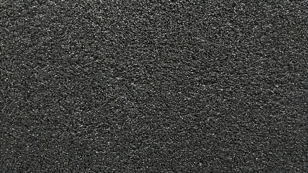 Μαύρη υφή που αποτελείται από πολλούς μικρούς κόκκους. σοβάς Φωτογραφία Αρχείου