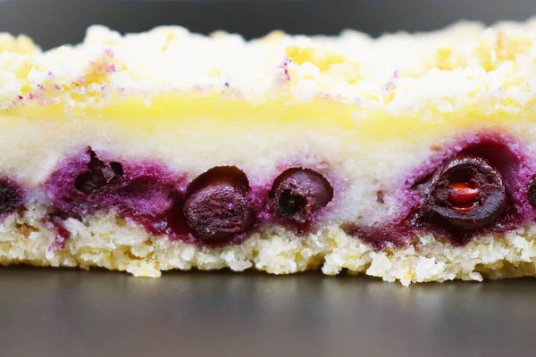 piece of pie with purple berries in a white biscuit closeup.