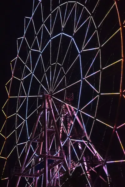 Ferris wheel at night glows with LED lights. Neon patterns in the dark — Stock Photo, Image