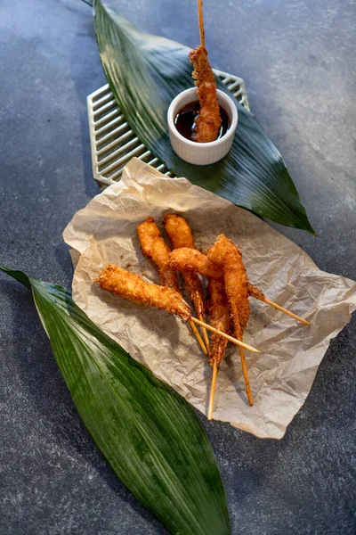 Deep-frying shrimps on craft paper with teriyaki