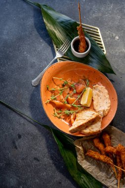 Dilimlenmiş somon tostlu ve taştan soslu.