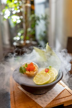 Havyar ve limonlu deniz tarağı Asya usulü yaz terasında dumanla bokeh