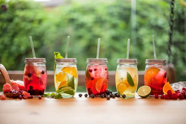 Yaz mevsiminde bahar terası masasında limonata ve yapraklı meyveler. 