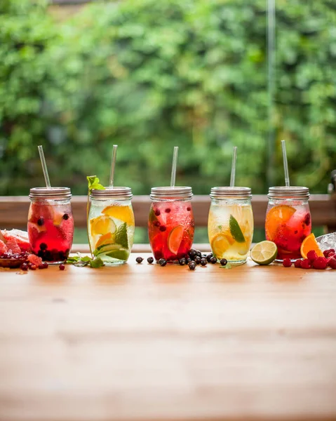 Yaz mevsiminde bahar terası masasında limonata ve yapraklı meyveler. 