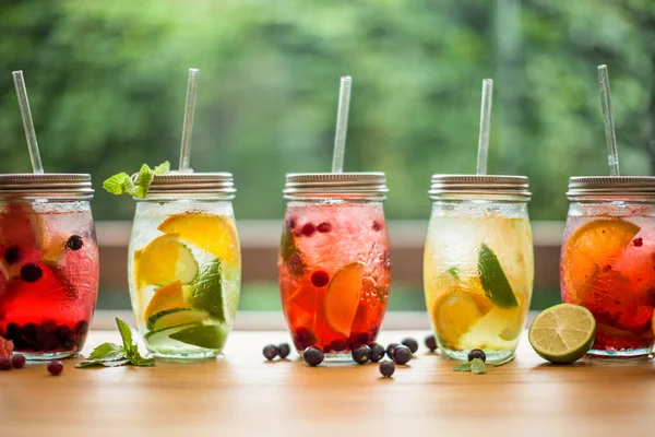 Yaz mevsiminde bahar terası masasında limonata ve yapraklı meyveler. 
