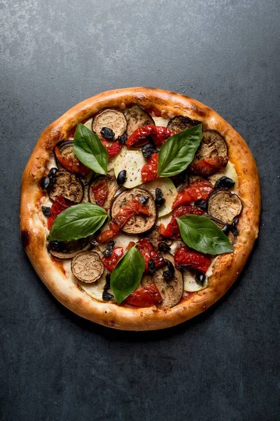İtalyan pizzası ve siyah arka planda fesleğen peynirli biber ve sos.